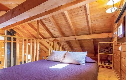 埃尔加斯托尔Cabana La Encina的木墙客房设有一间带紫色床的卧室