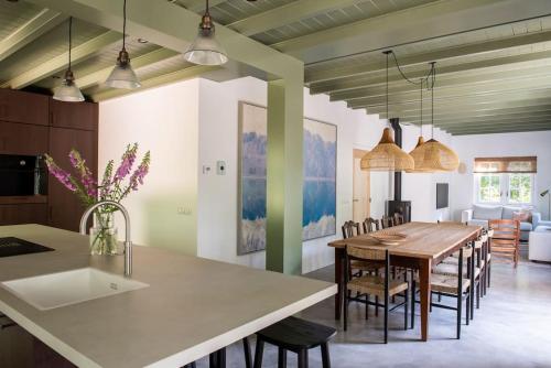 卢特伦Fantastisch familiehuis met grote tuin I Bosrijk的厨房以及带桌椅的用餐室。