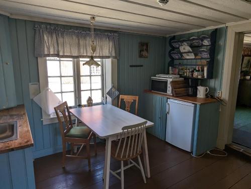 腓特烈斯塔Magasinet的厨房拥有蓝色的墙壁,配有桌椅