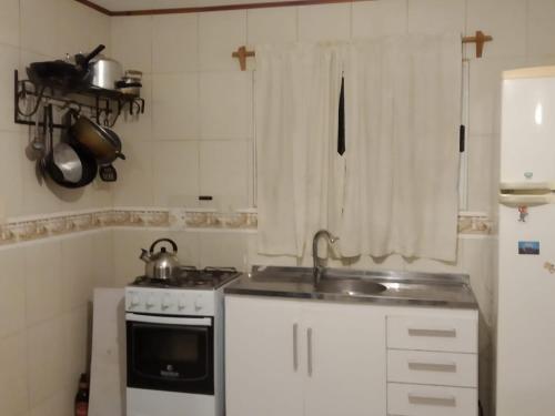 梅塞德斯La Solita的一间带水槽和炉灶的小厨房