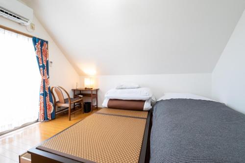 大津Hiei Blue Roof - Vacation STAY 13887的一间卧室配有一张床、一张书桌和一个窗户。