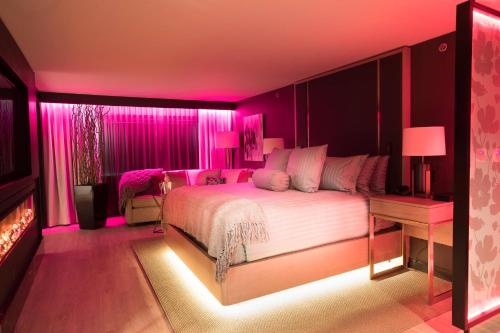 尼亚加拉瀑布尼亚加拉瀑布喜来登酒店的粉红色的卧室设有一张床和一个壁炉