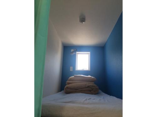 神户GuestHouse Geragera - Vacation STAY 95129v的一间卧室设有蓝色的墙壁和小窗户。