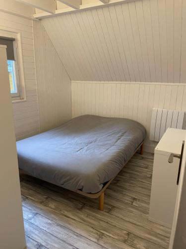 卡布尔Chalet rénové Cabourg的白色墙壁间的一张床位