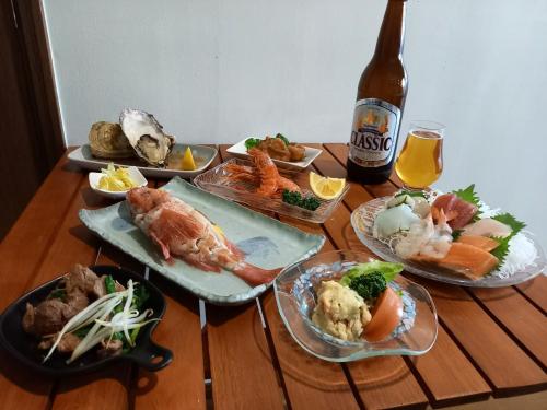 网走市Abashirikai no Taiyo - Vacation STAY 14415的一张桌子,上面放着盘子和一瓶啤酒