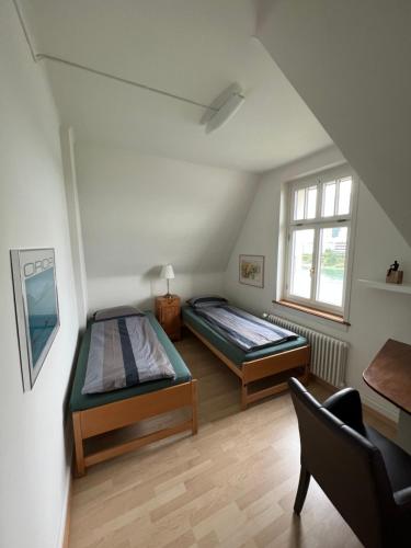 巴塞尔Charmante Altbauwohnung am Rhein的一间卧室配有两张床和椅子