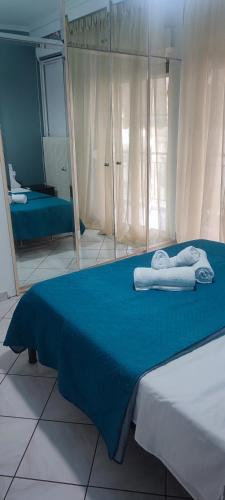 卡瓦拉Valantis House的一间卧室配有蓝色的床和毛巾