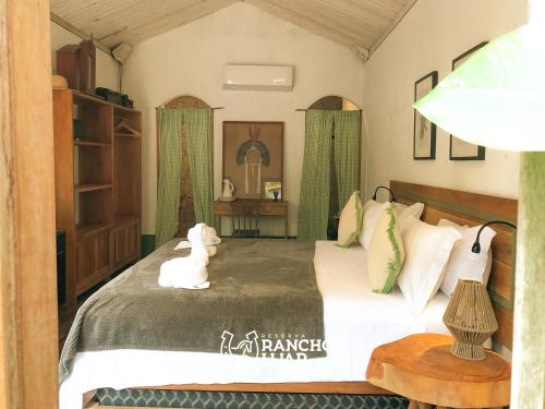 佩德拉斯港Pousada Rancho Luar的一间卧室配有一张带绿色窗帘的大床