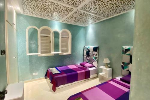 卡博尼格洛Bahia del cabo的一间紫色卧室,房间内设有一张紫色的床