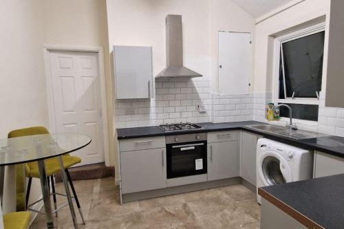 达特福德Two Bedroom Maisonette in Erith的厨房配有炉灶、水槽和洗碗机。
