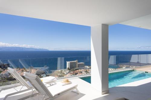 桑蒂亚戈德尔泰德Crystal I Luxury Apartments by EnjoyaHome的一个带两把椅子的阳台和一个游泳池
