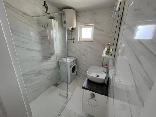 赫瓦尔La Fee studio apartment的带淋浴和盥洗盆的白色浴室