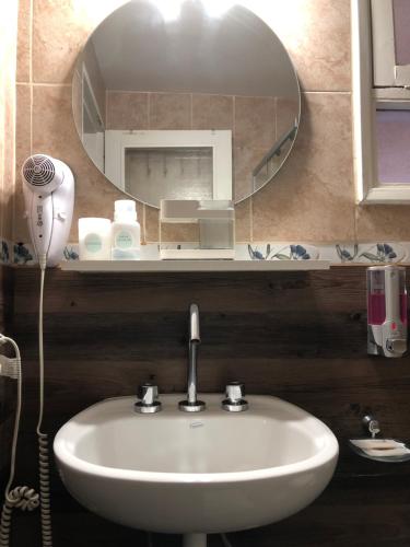 门多萨Mendoza Centro Aparment的浴室设有白色水槽和镜子