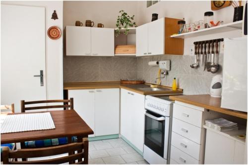 泰尔奇普里瓦40号酒店的厨房配有白色橱柜和木桌