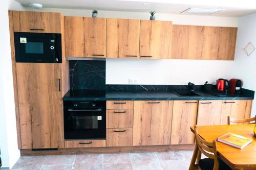 马洛塞讷Chez Marien的厨房配有木制橱柜和黑色用具