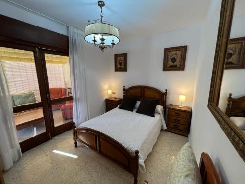 桑亨霍Apartamento en Nanin-Sanxenxo的一间卧室配有一张床、镜子和吊灯