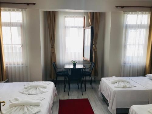 伊斯坦布尔Halil Bey Konağı的客房设有两张床、一张桌子和镜子