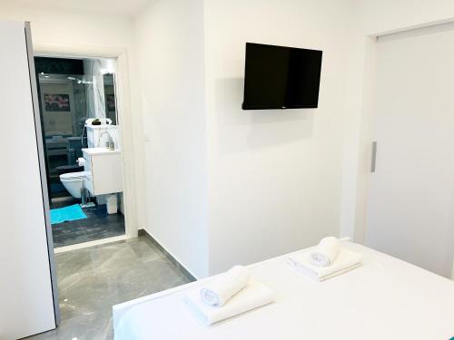科尔丘拉Orhideja的一间白色客房,配有电视和2条白色毛巾