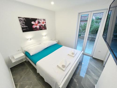 科尔丘拉Orhideja的一间白色的小卧室,配有床和窗户