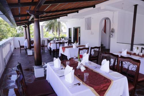 蓬蒂切里拉夏杜酒店的一间设有白色桌椅的用餐室