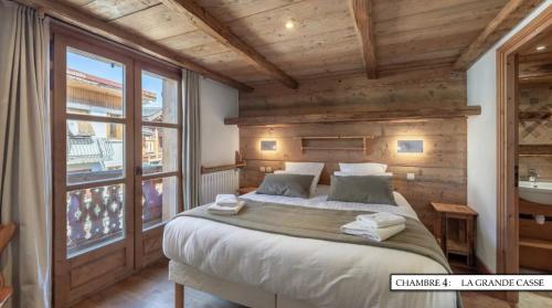 谷雪维尔Chalet K120 - Village du Praz - Courchevel的一间卧室设有一张大床和一个大窗户