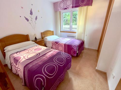 拉科萨加拿大公寓 的配有紫色和白色床单的客房内的两张床