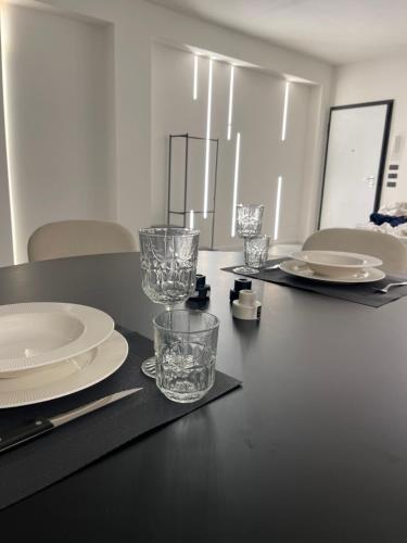 玛格丽塔萨沃亚Casa Mare Design的一张黑桌,上面有盘子和玻璃杯