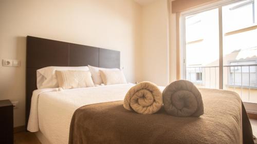 阿瓜尔达Apartamento nuevo al lado de la playa en A Guarda的一间卧室配有带毛巾的床