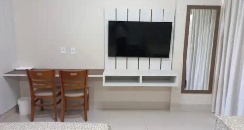 卡达斯诺瓦斯SPAZZIO Andrian & Silva - INCLUSOS INGRESSOS DO PARQUE的客厅配有电视和桌椅