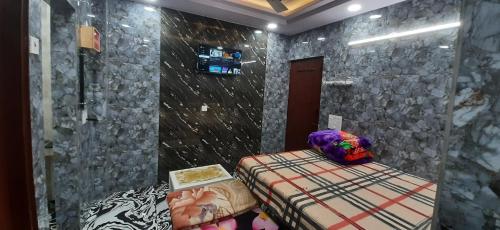 新德里Aggarwal luxury room with private kitchen washroom and balcony along with fridge, Ac, Android tv, wifi in main lajpat nagar的一间卧室设有一张床和石墙