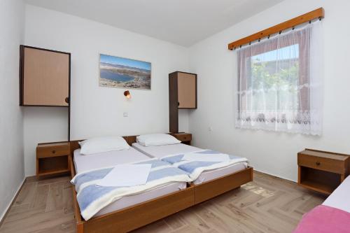 博罗维奇Apartments with a parking space Potocnica, Pag - 6338的一间卧室设有两张床和窗户。
