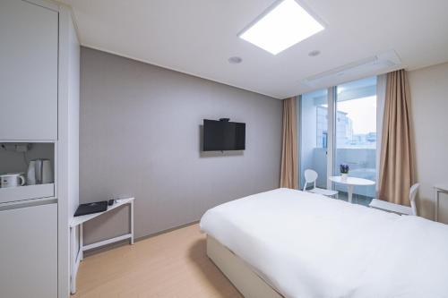 春川Chuncheon Bella Residence的一间酒店客房,配有一张床和一台电视