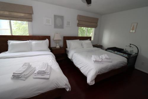 弗吉尼亚海滩Cheerful Beach Townhouse的一间卧室配有两张床和白色毛巾。