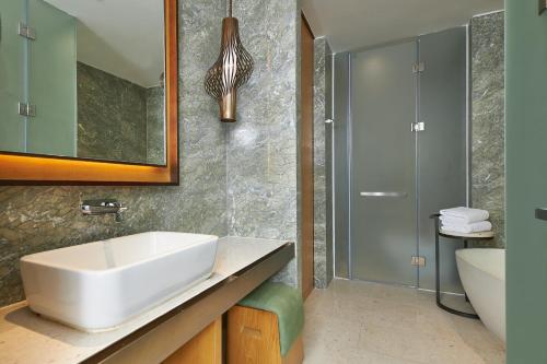 万宁石梅湾威斯汀度假酒店(三亚机场/免税店/动车站穿梭巴士+专业旅拍送精选照片）的浴室设有白色水槽和镜子
