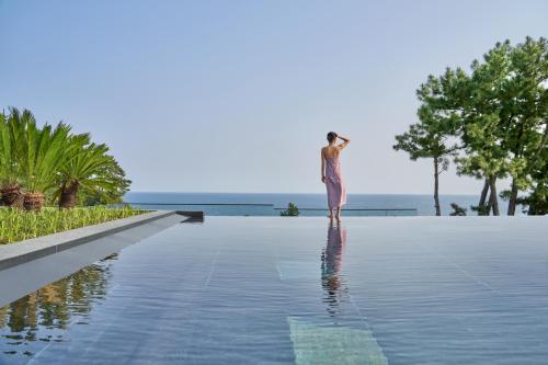 西归浦市JW Marriott Jeju Resort & Spa的站在游泳池边缘的女人