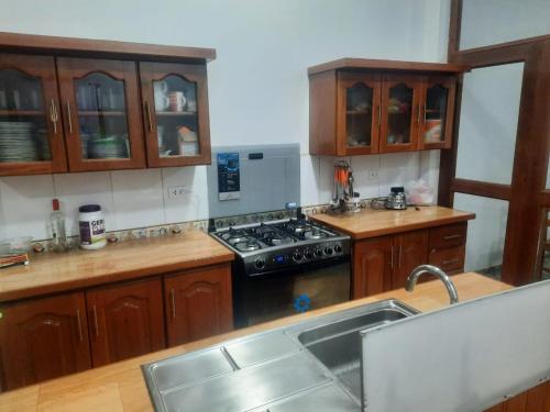 伊基托斯Casa Grande的厨房配有木制橱柜和炉灶烤箱。