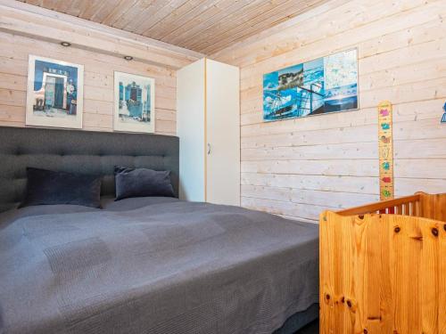哈博尔Holiday home Harboøre XXIII的一间卧室设有一张床和木墙