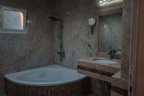 八田Hatta Orchard的带浴缸、水槽和镜子的浴室