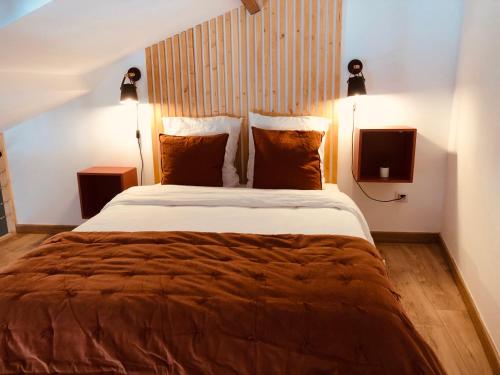 绍维尼Gites De la Cour au Grenier的一间卧室配有一张大床、两盏灯和一台电视。