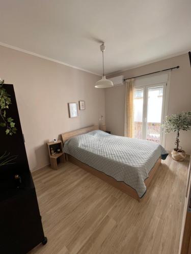 希俄斯inHeart Apartment Chios的一间卧室设有一张床和一个大窗户