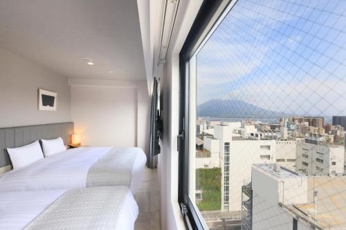 鹿儿岛QuintessaHotel KagoshimaTenmonkan Relax&Sleep的一间卧室设有两张床和大窗户
