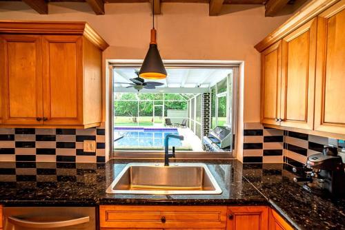 迈阿密Luxury Miami Village w/Pool+Grill+MiniGolf的一个带水槽的厨房,享有游泳池的景色