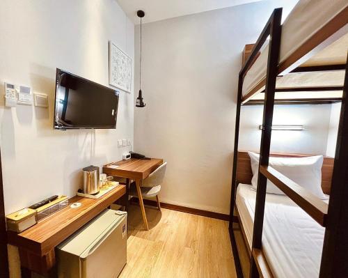巴淡岛中心oxy suites G-03 at Shop House Meisterstadt Pollux Habibie的客房设有一张桌子和一张双层床。