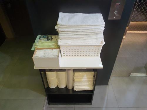 首尔Hotel Daisy的衣柜架上的毛巾堆