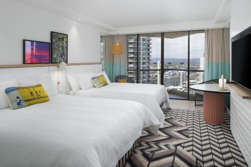 黄金海岸黄金海岸QT精品度假酒店的酒店客房设有两张床和大窗户。