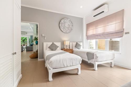 拉迈2BR Villa Baan Orchid, seconds to beach的一间白色卧室,配有两张床和窗户