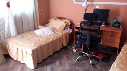 亚的斯亚贝巴Birhan Villa的一间卧室配有一张床和一张带电脑的书桌