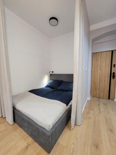 科瓦雷Apartament Sztolnia的一间卧室配有一张带蓝色毯子的床