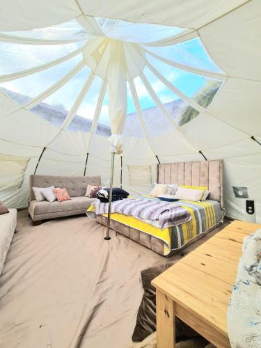 基多Hermoso Glamping en Quinta Privada的帐篷内的卧室,配有一张床和一张桌子