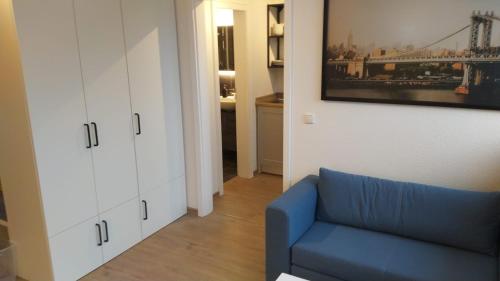 门兴格拉德巴赫Frisch renoviertes Appartement的客厅配有蓝色沙发和白色橱柜